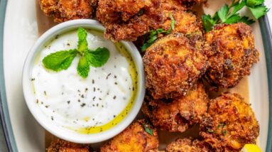 Vegetarian Meatballs arranged on an oval platter, with a white dipping sauce in a bowl.